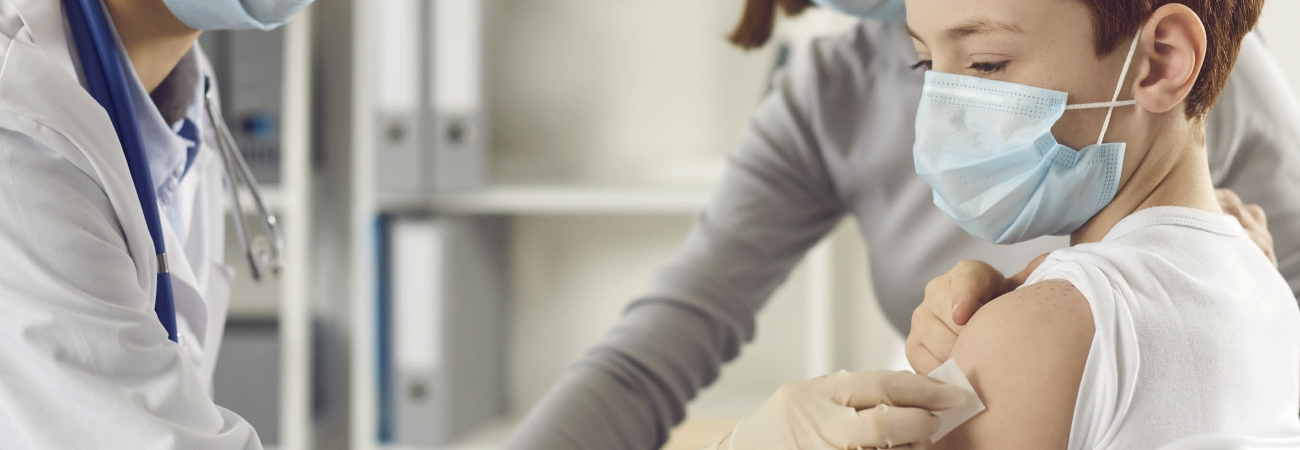 Young child receiving vaccine shot from doctor