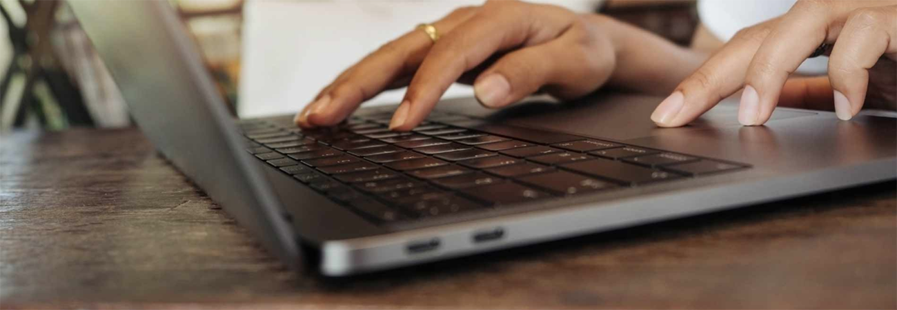 Hands typing on laptop