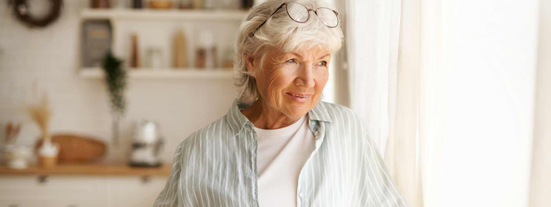 hero-older-woman-looking-out-window-medicare