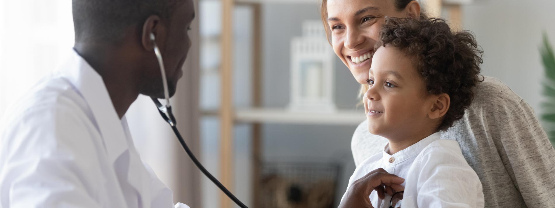 Pediatrician-holding-stethoscope-on-young-child-patient