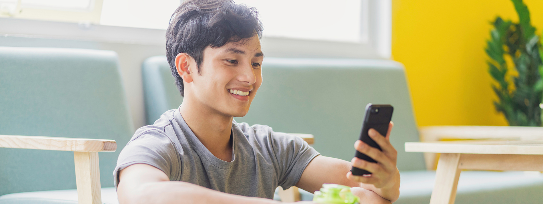 smiling-man-using-phone_1900x713