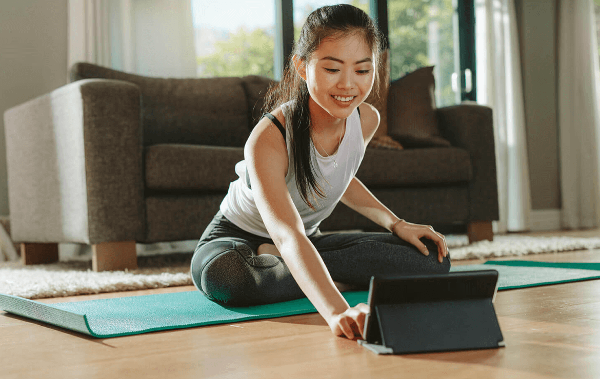 https://www.sharphealthplan.com/images/default-source/site-images/hero-images/woman-sitting-on-yoga-mat-in-living-room-scrolling-on-tablet.png?sfvrsn=cbc5a380_1