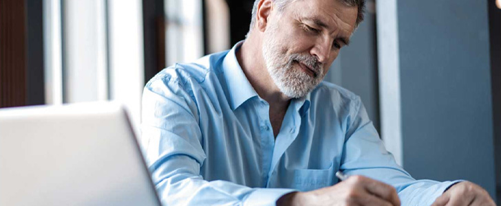 Older man writing down notes