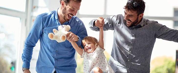 Two men holding child's hands