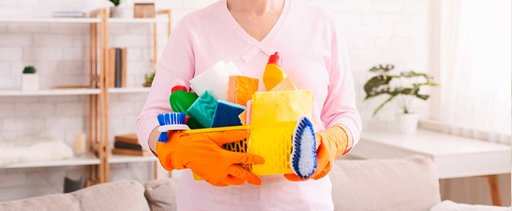 Hands holding various types of cleaning products and tools