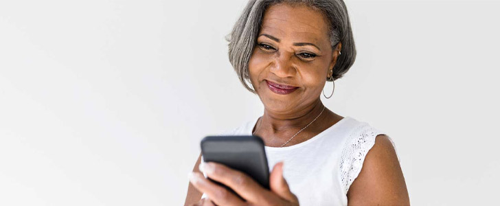 Older woman smiling while using mobile phone