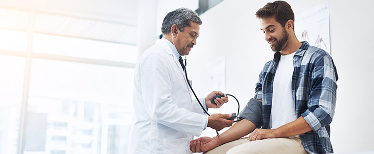 A doctor checking a patient's blood pressure