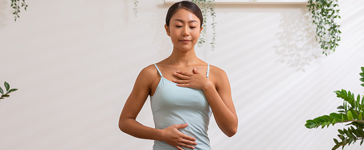 Woman doing breathing exercise before practicing yoga