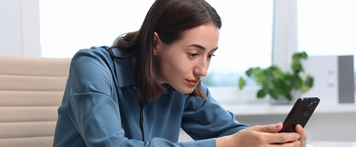 Woman hunching while viewing smartphone