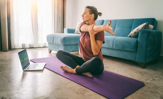 mujer haciendo ejercicios de estiramiento en una colchoneta de yoga