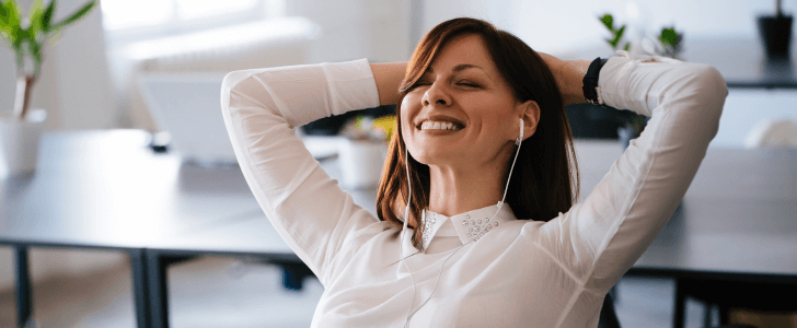 Woman wearing earbuds putting hands behind head to relax